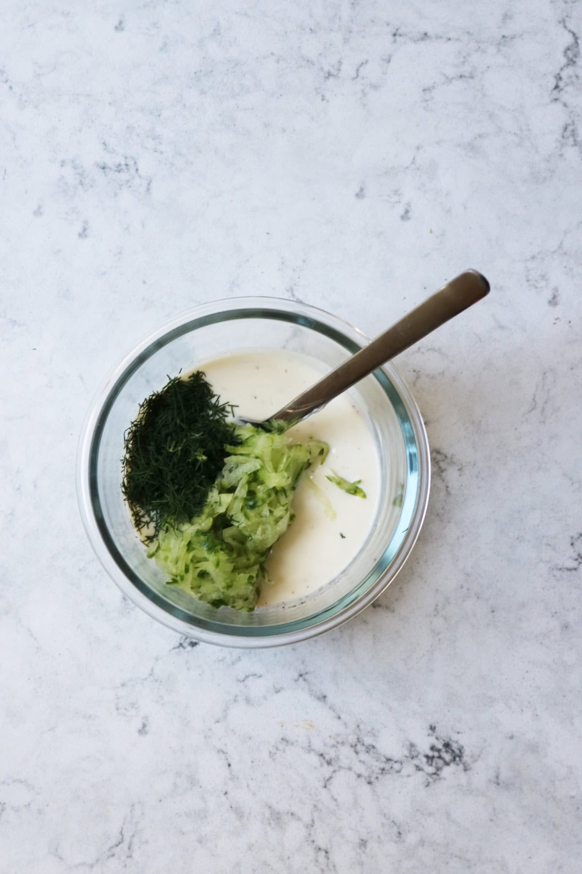 Mixing cucumber and dill into vegan tzatziki