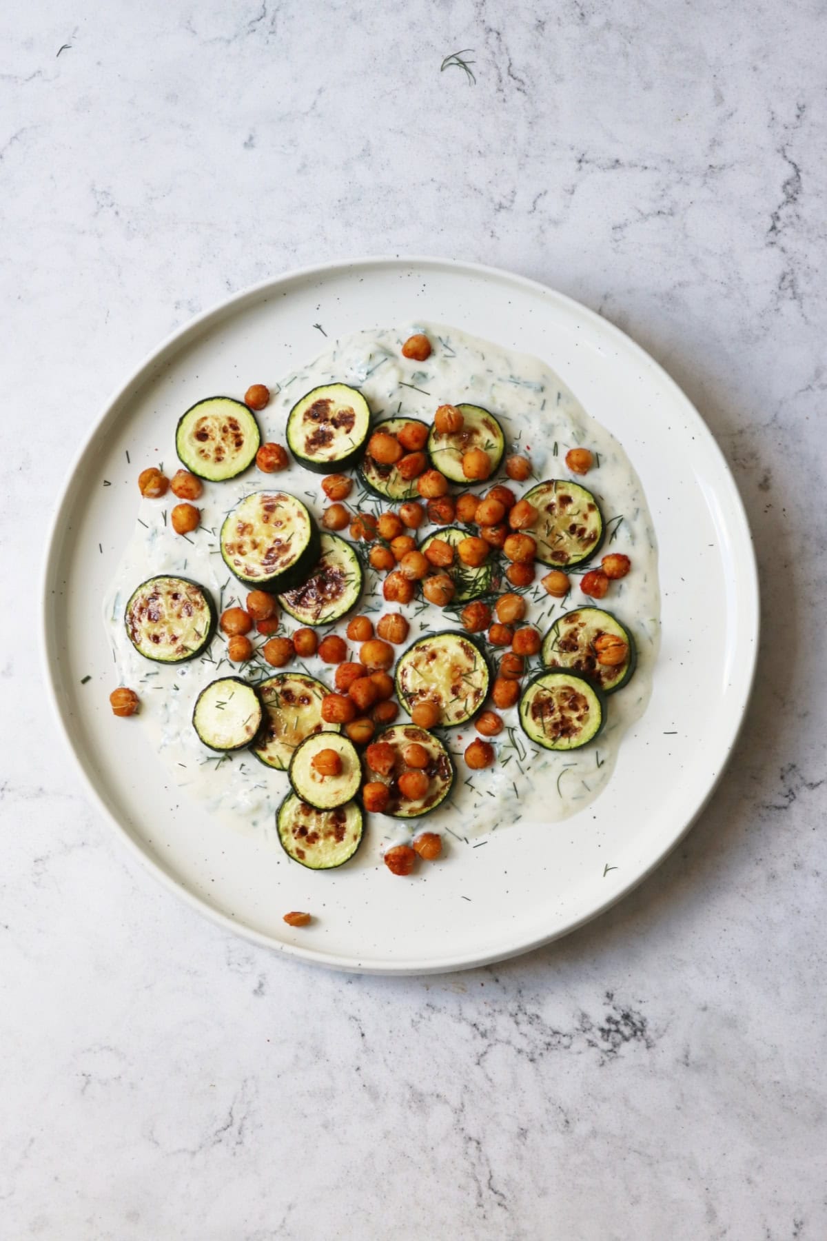Baby courgettes crispy chickpeas and vegan tzatziki on a plate