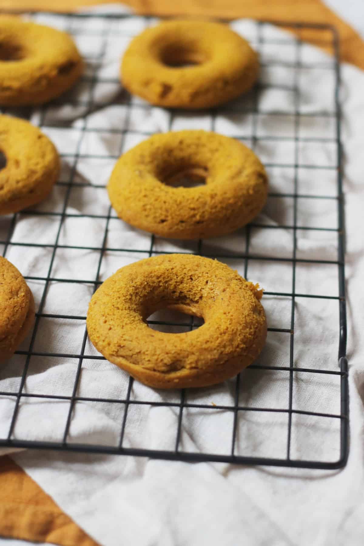 Vegan Baked Pumpkin Spice Doughnuts on a wire rack