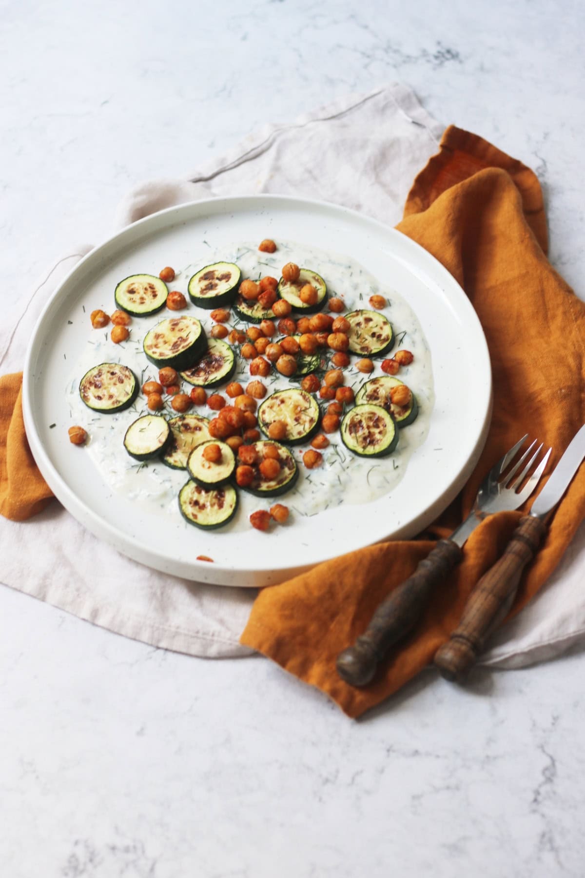 Baby courgettes crispy chickpeas and vegan tzatziki on a plate