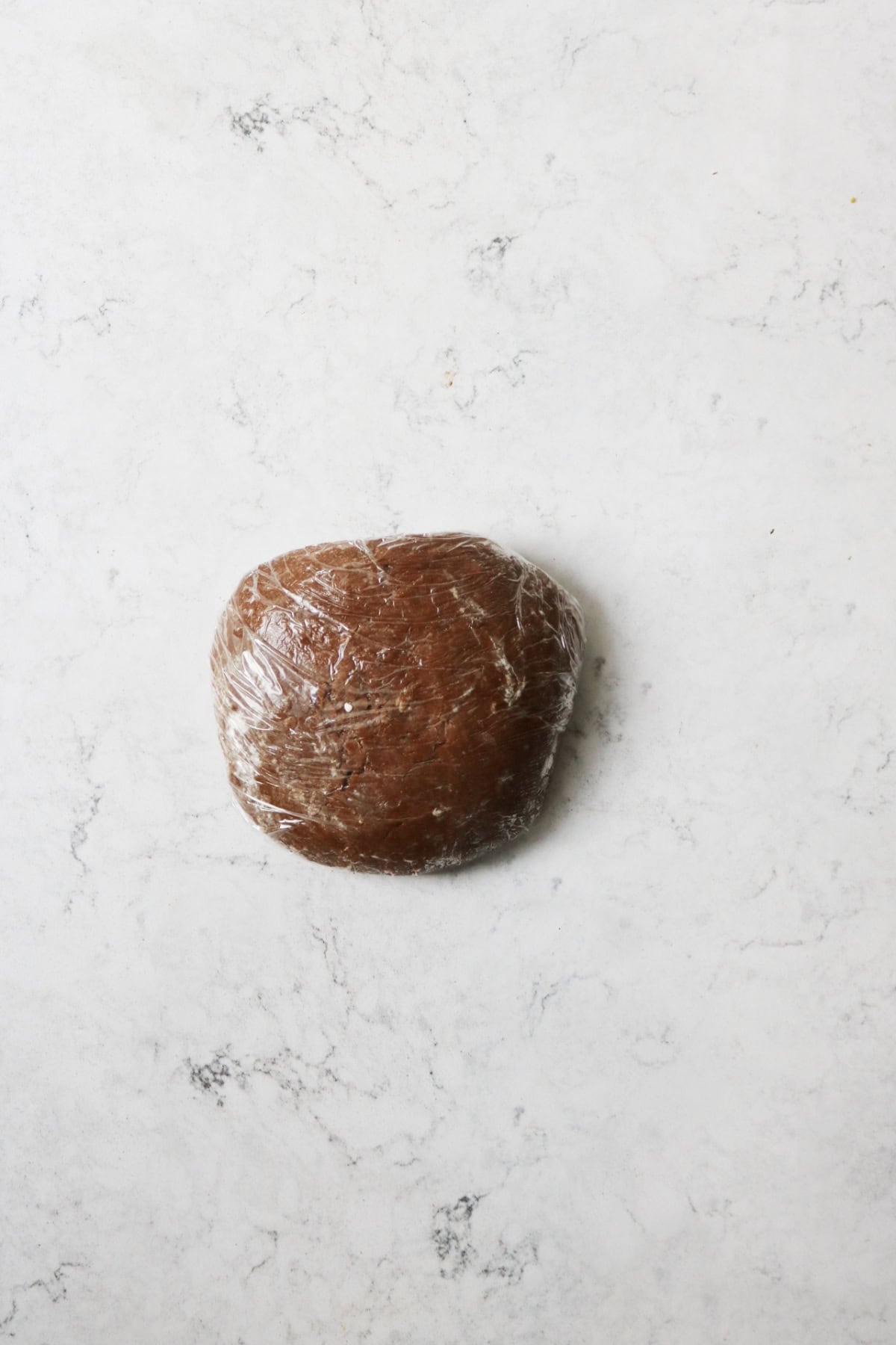 Ball of gingerbread dough wrapped in clingfilm