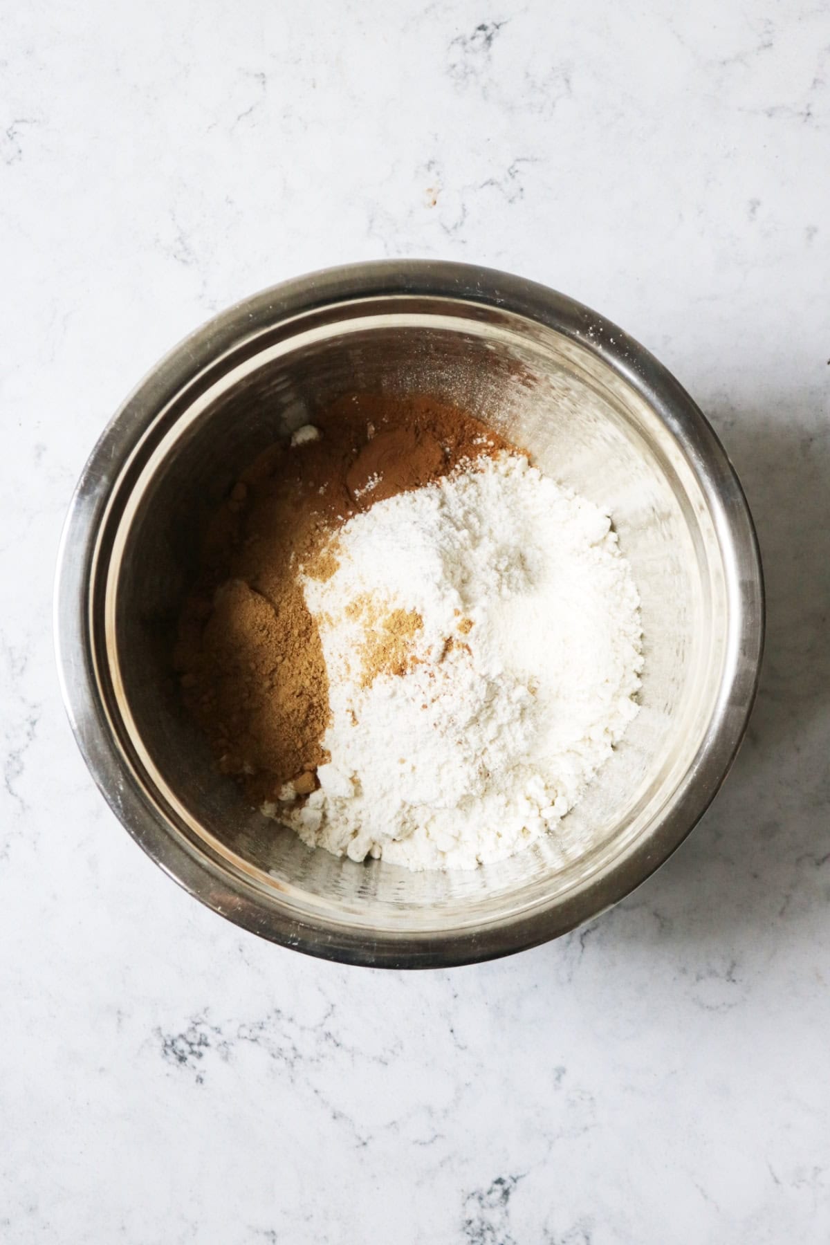 Self raising flour, ground cinnamon and ground ginger in a mixing bowl