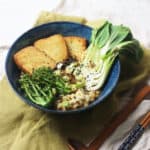 A bowl of vegan ramen topped with smoked tofu, tenderstem broccoli, spring onions, sesame seeds and pak choi