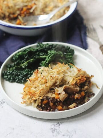 A portion of Rösti-Topped Puy Lentil and Mushroom Pie served with cavolo nero