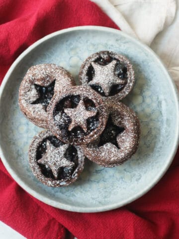 Vegan Chocolate and Cherry Mince Pies on a plate with a red napkin