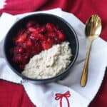 Apple and Cranberry Porridge in a bowl served with a Christmas bow napkin.