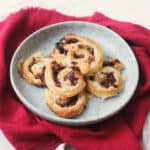 A plate of Vegan Sun-Dried Tomato and Feta Pinwheels on a red napkin