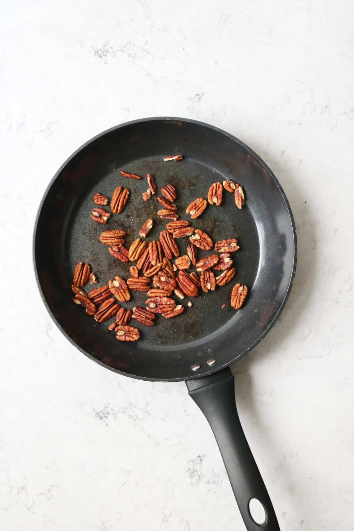 Pecans toasting in a dry frying pan