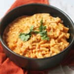 A bowl of Vegan Kimchi Mac and Cheese garnished with coriander