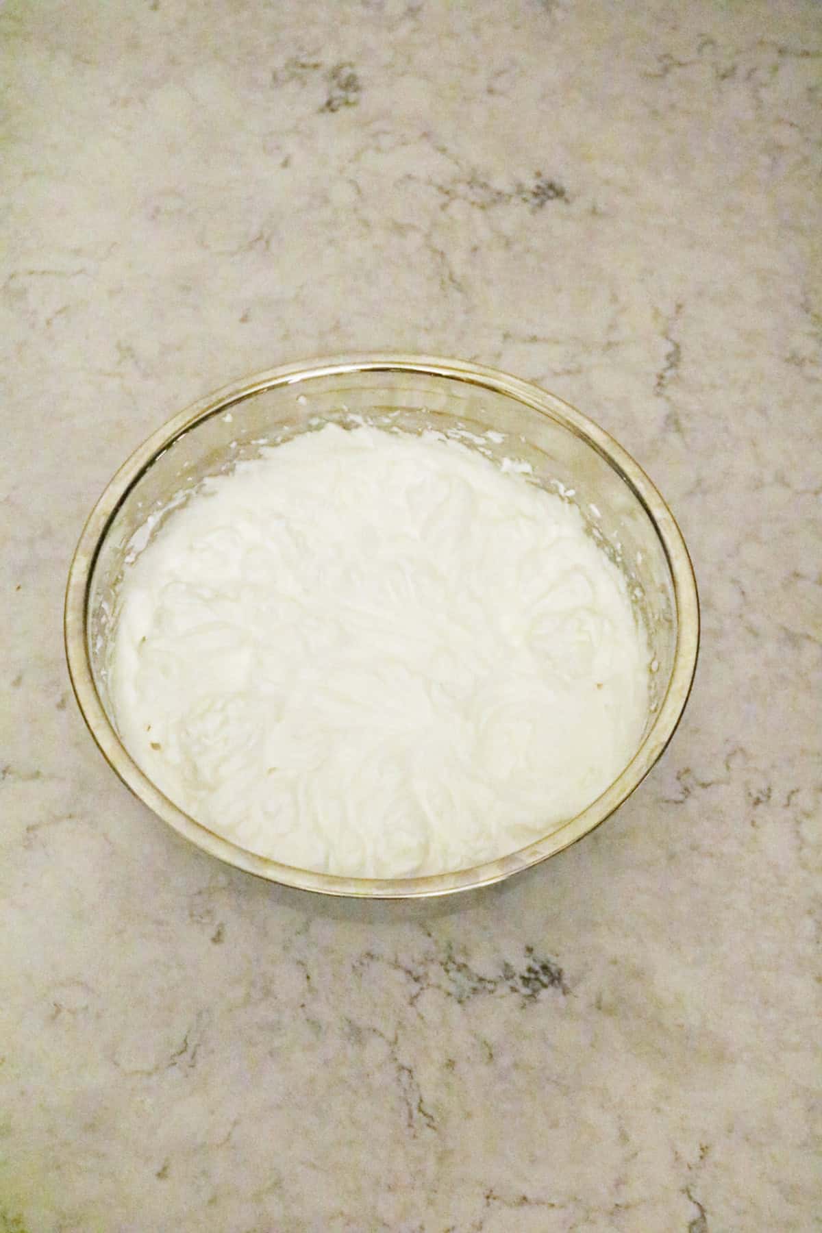 Vegan meringue in a metal bowl whipped to stiff peaks