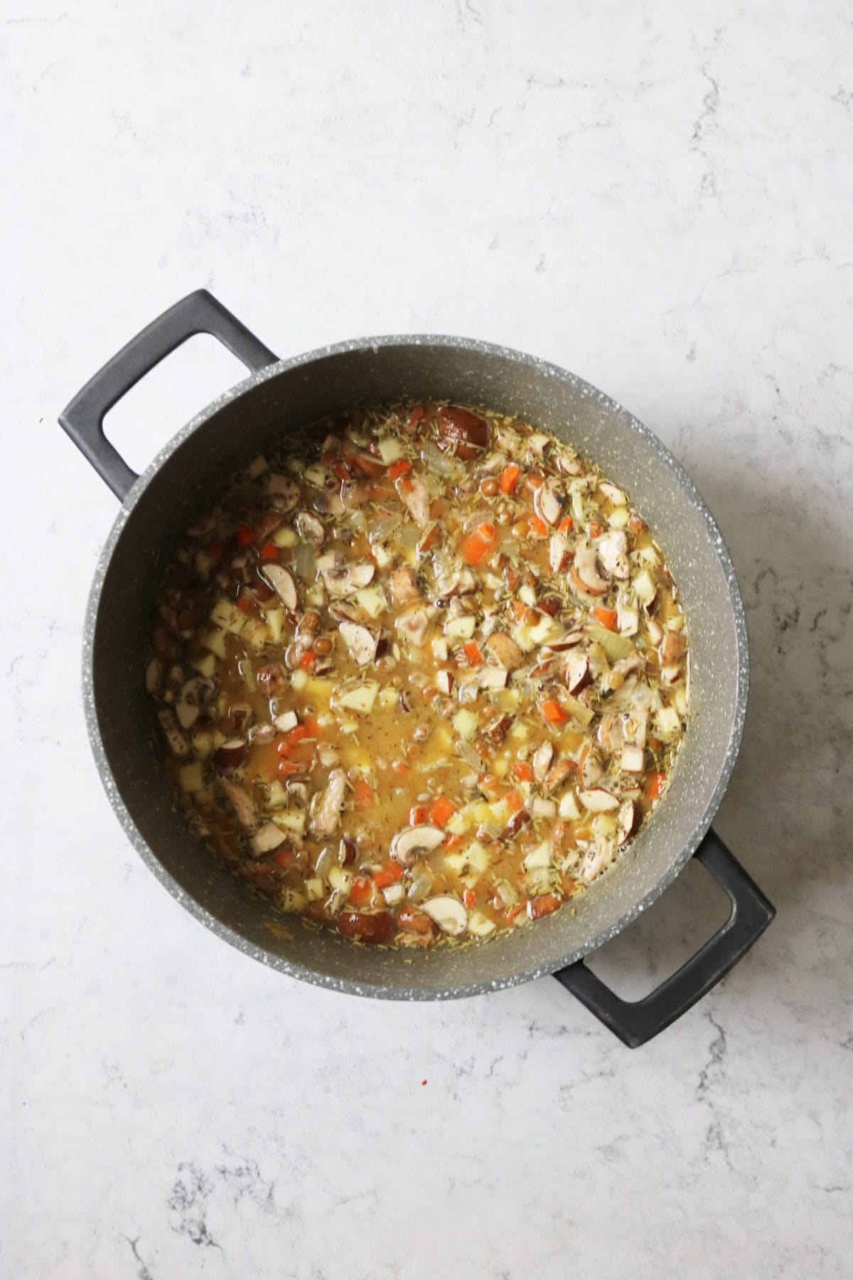 The filling of a Vegan Lancashire Hot Pot simmering in a large sauce pan
