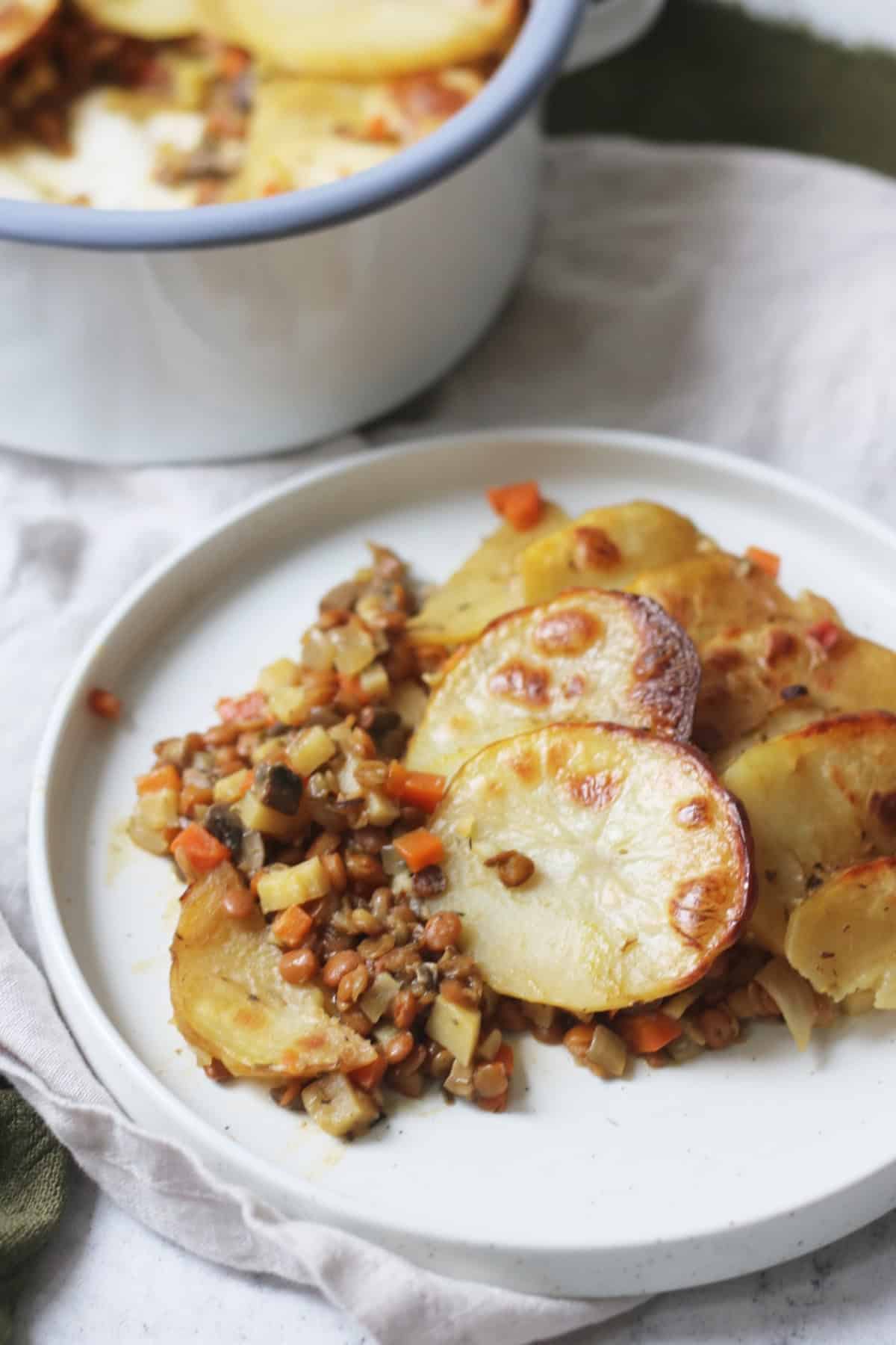 A close up of a plate of Vegan Lancashire Hot pot on a white and green napkin