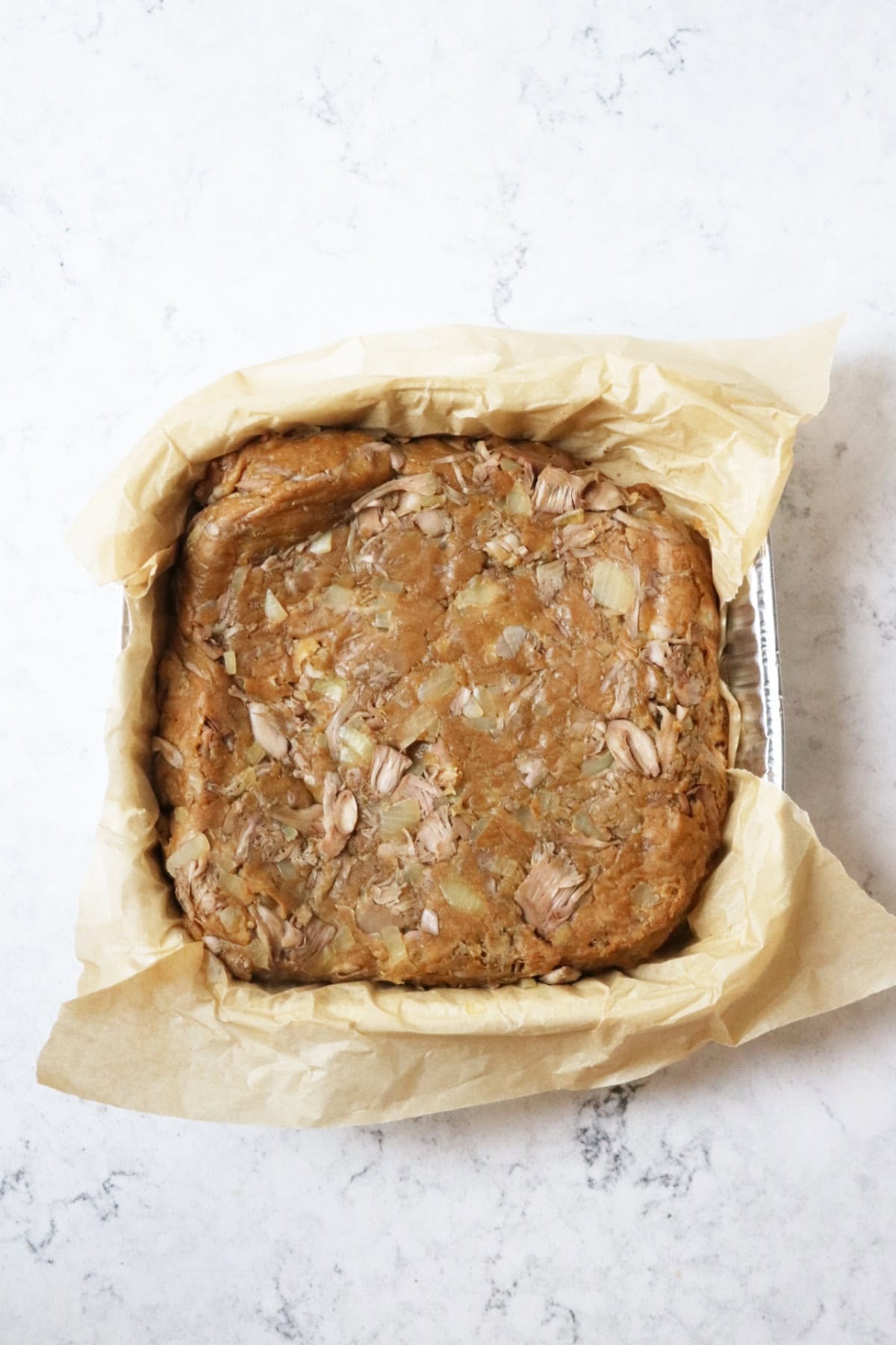 Chinese ribs cooking in a pan, flipped over before being covered with Chinese BBQ sauce