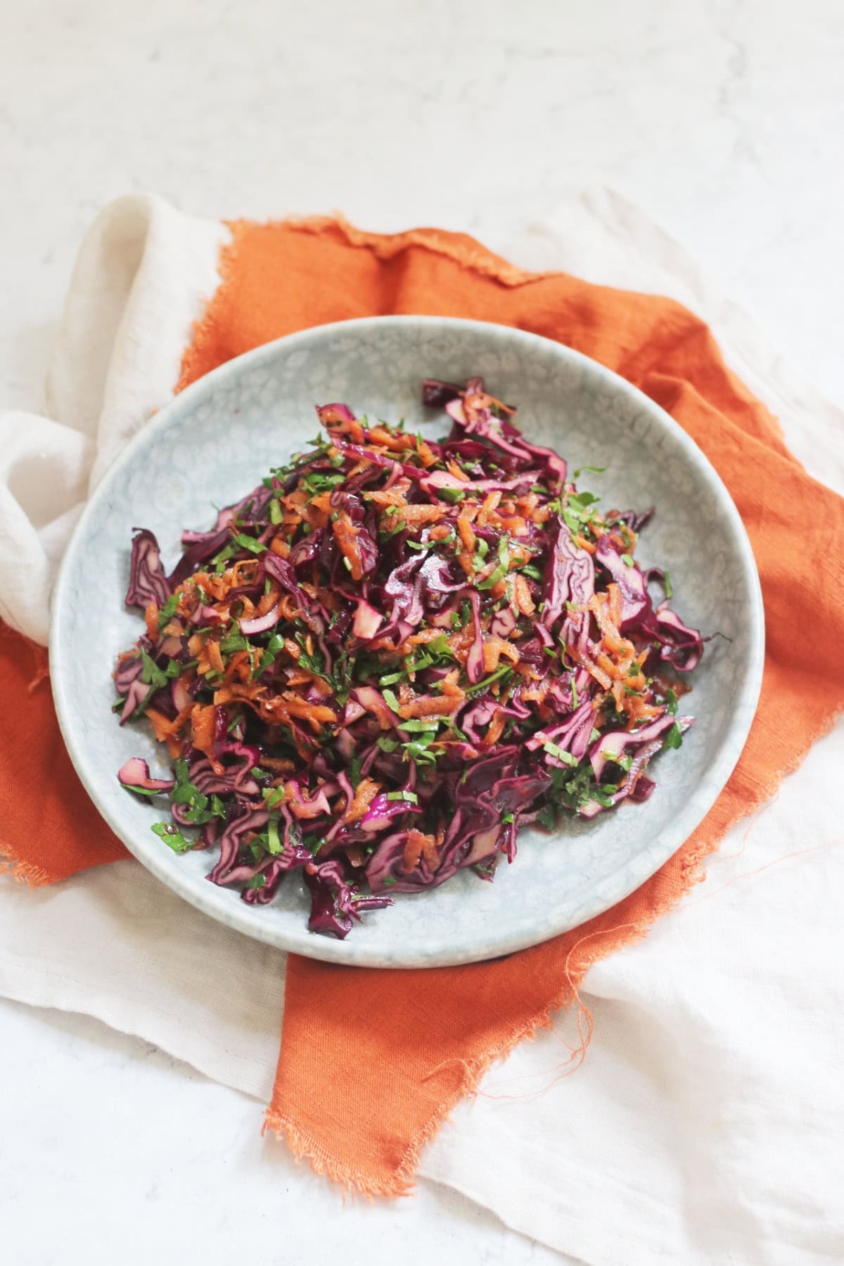 A plate of Turkish Red Cabbage Salad sat on top of a bright orange napkin