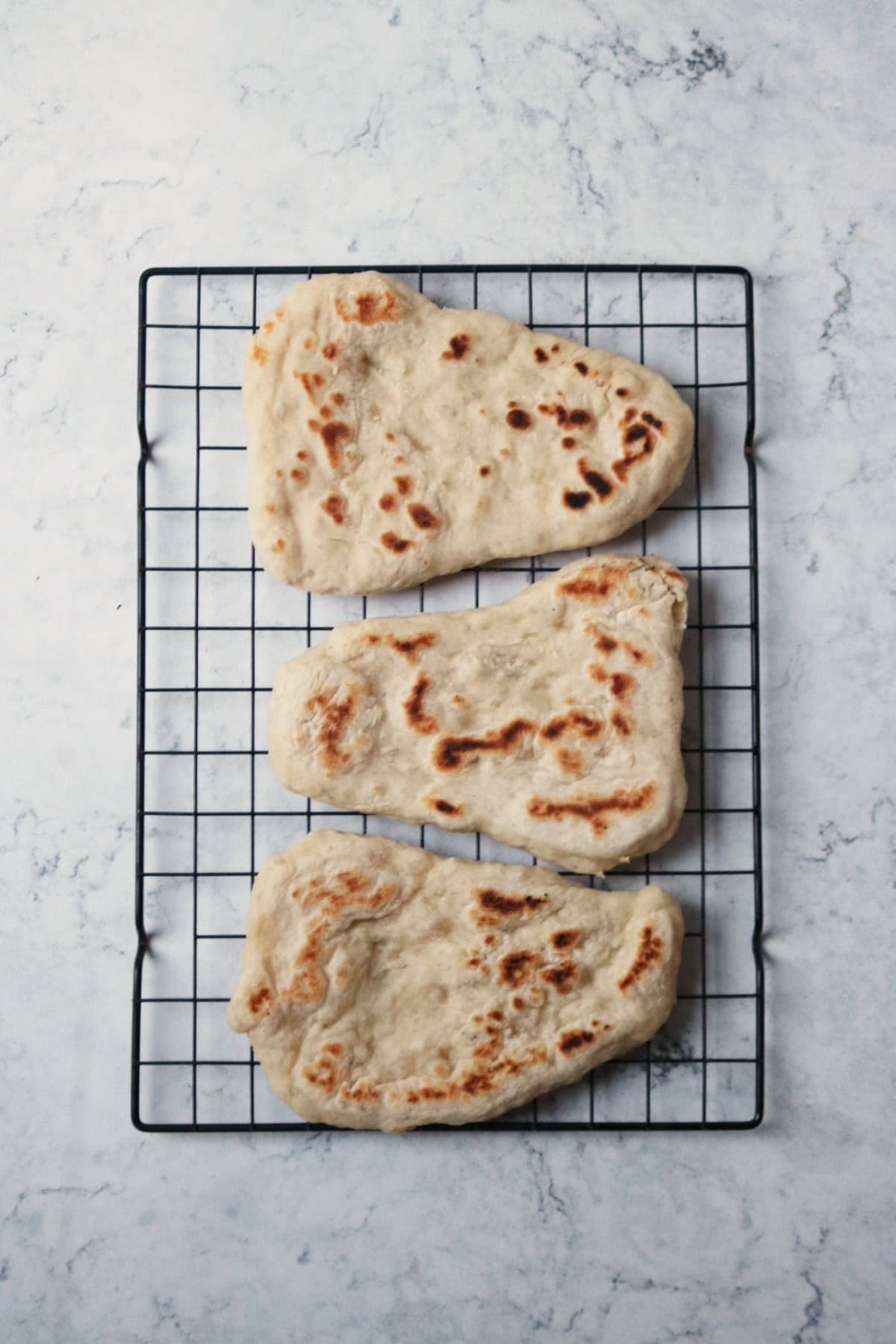 3 cooked Vegan Naan Breads cooling on a wire rack
