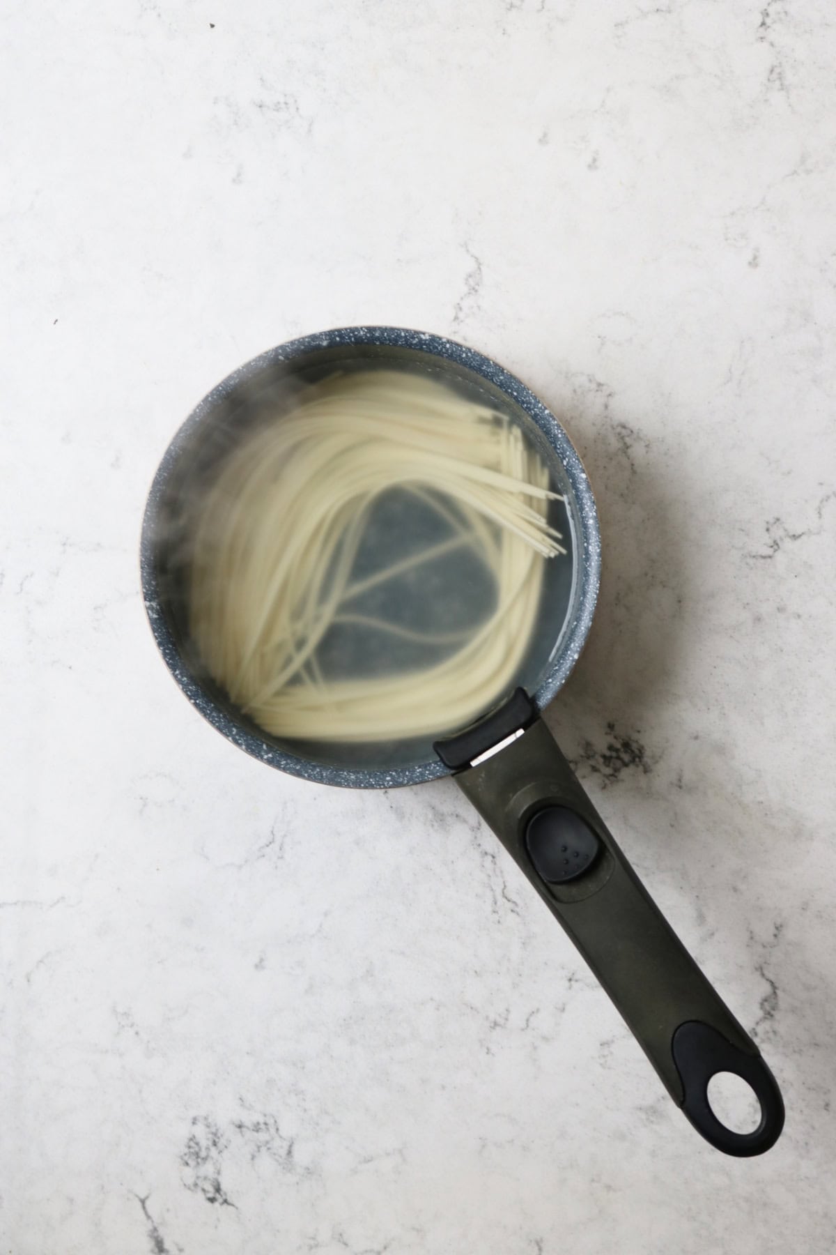 Ramen noodles cooking in a small saucepan