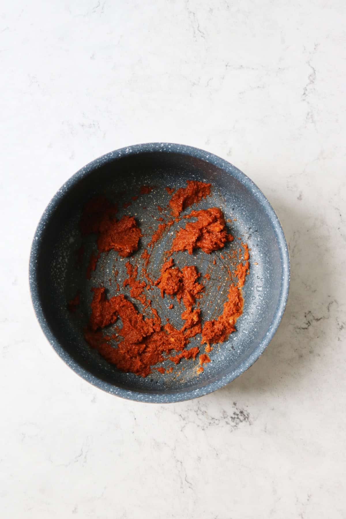 Thai red curry paste frying in a saucepan