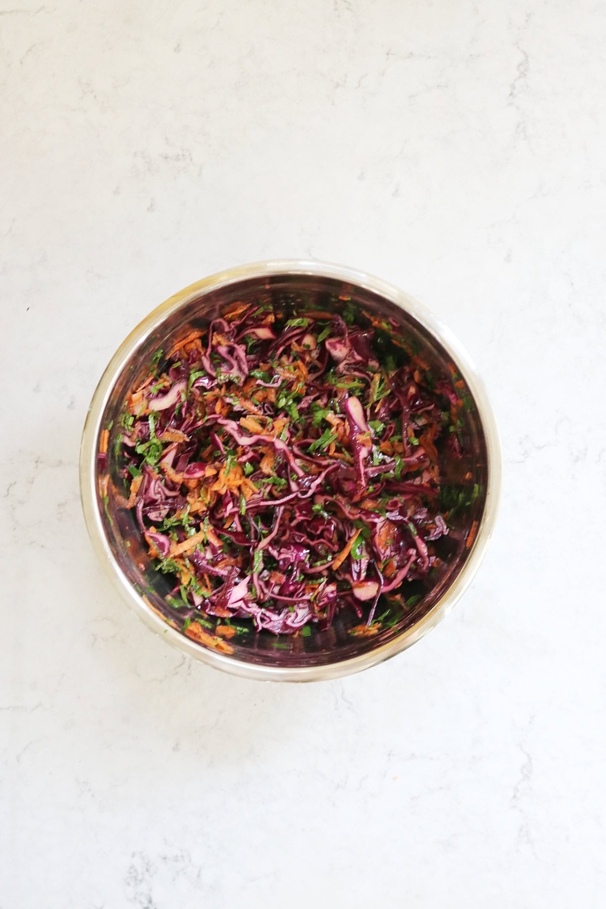 A large metal mixing bowl containing Turkish Red Cabbage Salad
