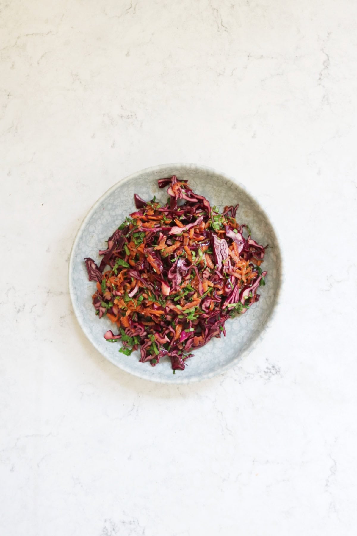 A plate of Turkish Red Cabbage Salad on a white marble counter top
