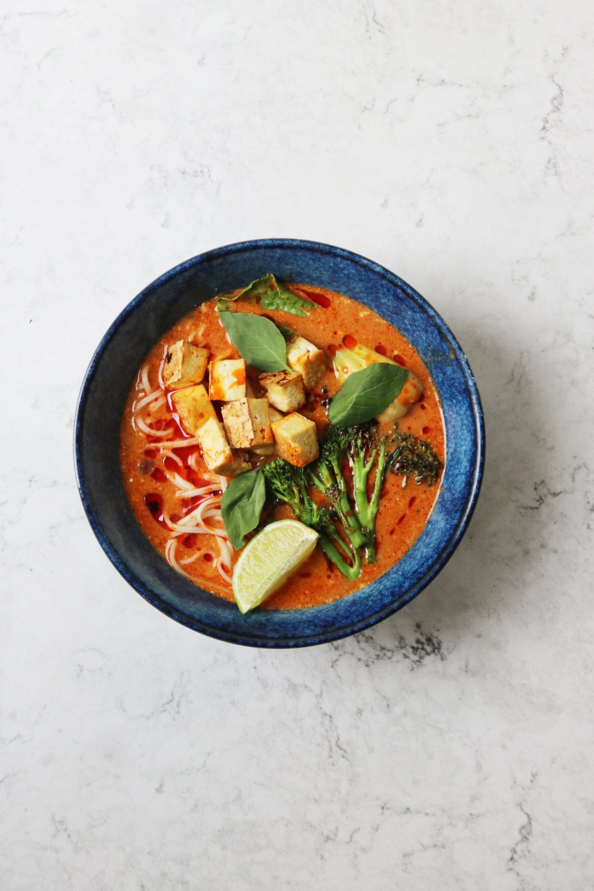 Vegan Thai Red Curry Noodle Soup served in a dark blue ramen bowl