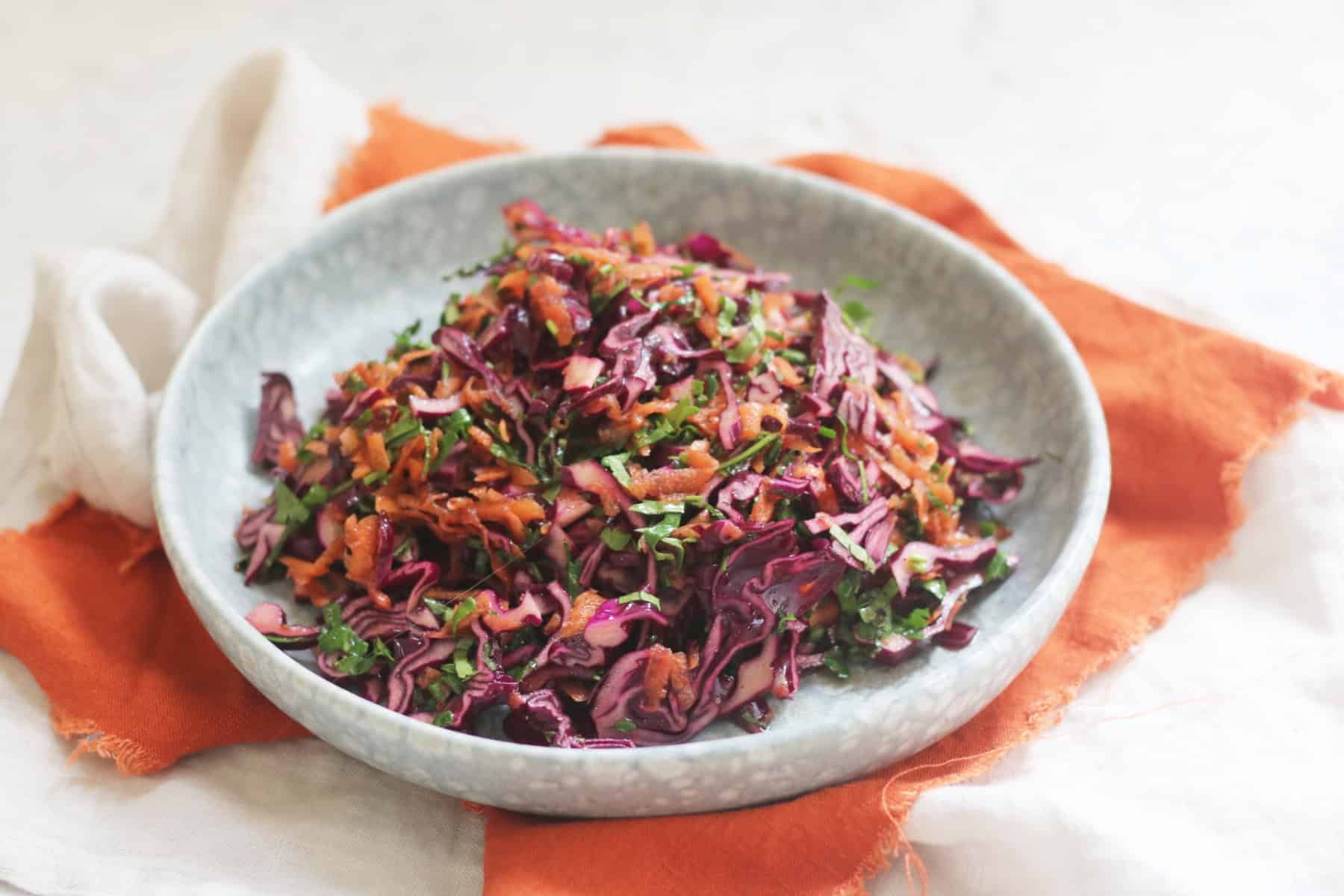 A plate of Turkish Red Cabbage Salad sat on top of a bright orange napkin