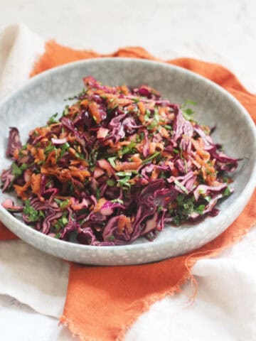 A plate of Turkish Red Cabbage Salad sat on top of a bright orange napkin