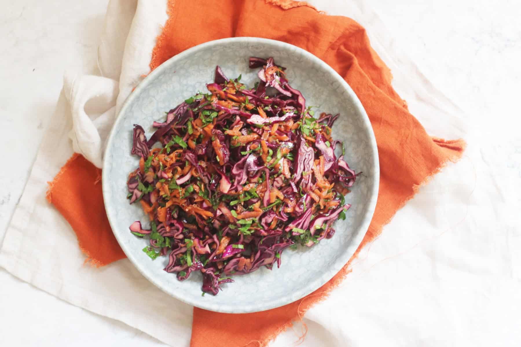 A plate of Turkish Red Cabbage Salad sat on top of a bright orange napkin