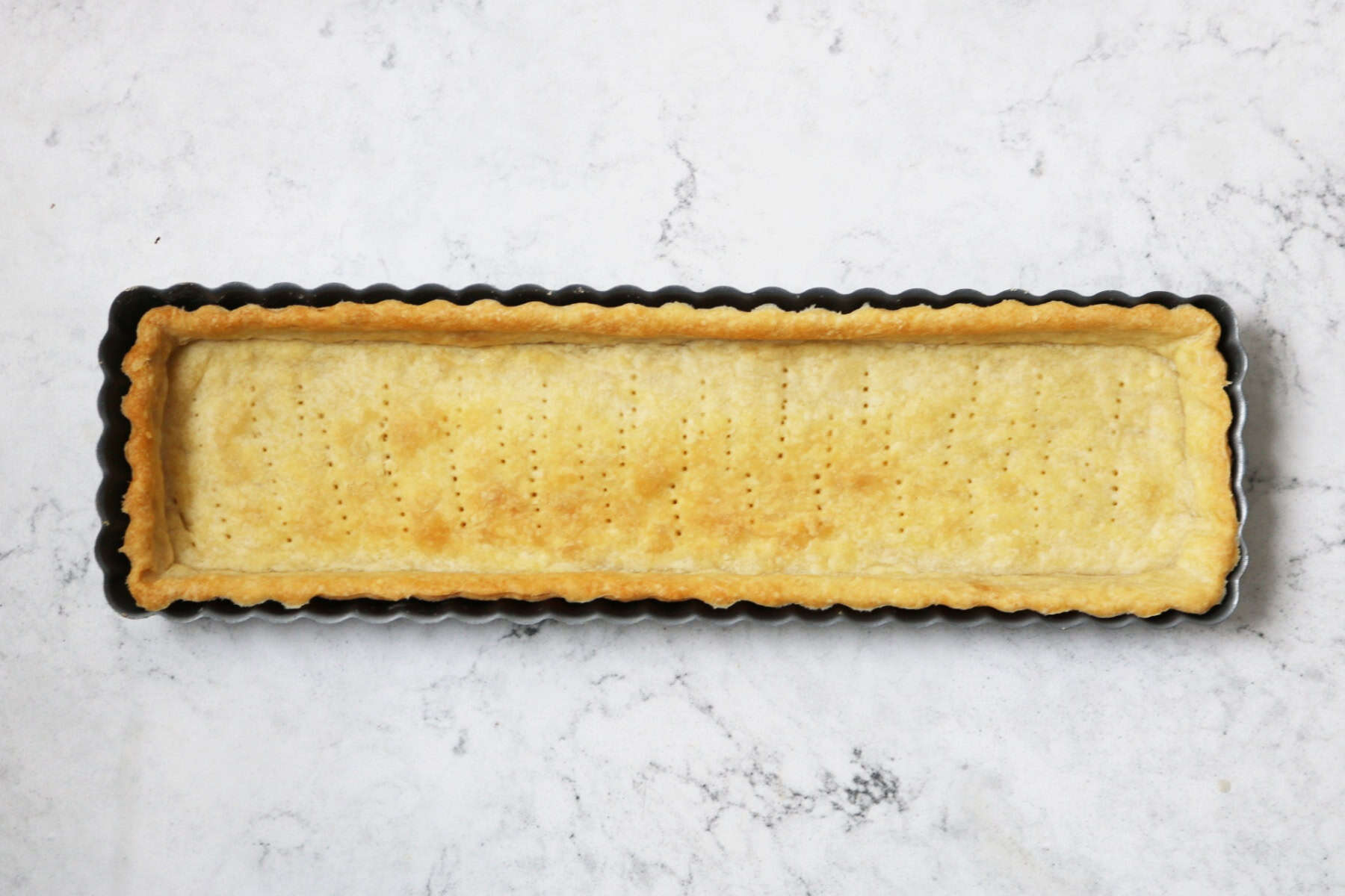 A baked rectangular shortcrust pastry tart case