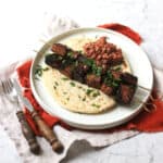 Pomegranate Molasses Tofu Kebabs served with a flatbread and a portion of muhammara (a roasted red pepper and walnut dip)