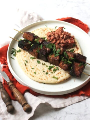 Pomegranate Molasses Tofu Kebabs served with a flatbread and a portion of muhammara (a roasted red pepper and walnut dip)