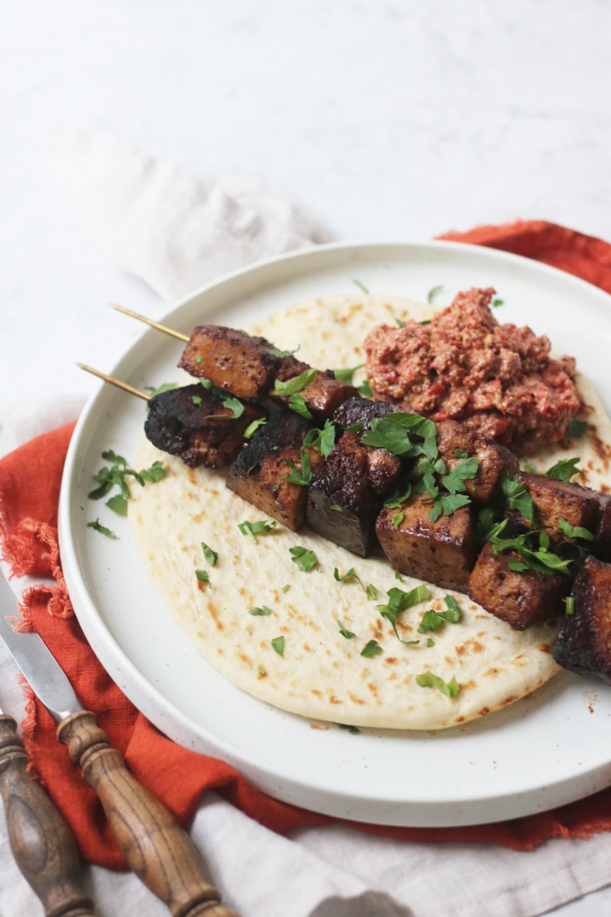 Pomegranate Molasses Tofu Kebabs served with a flatbread and a portion of muhammara (a roasted red pepper and walnut dip)
