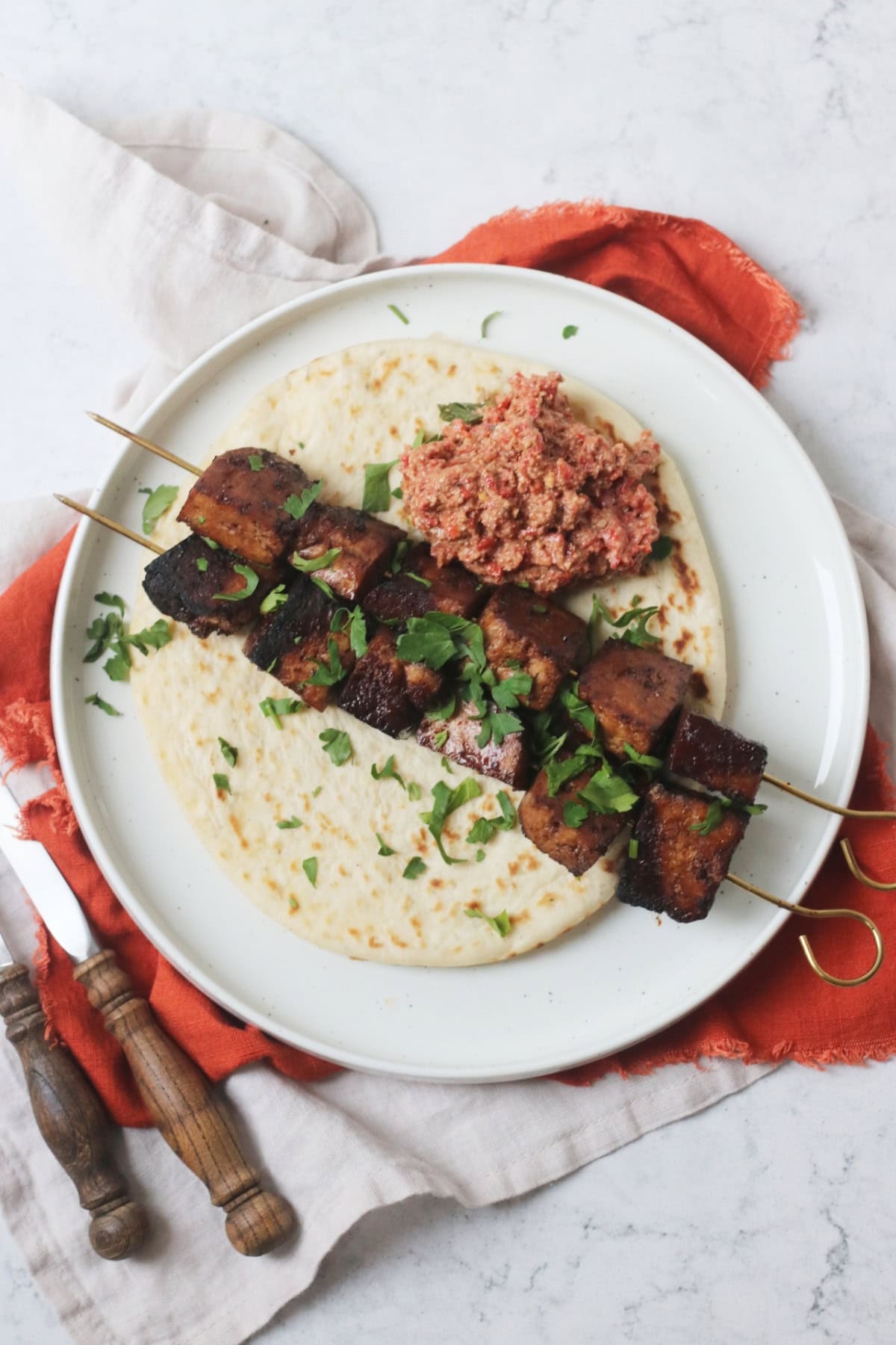 Pomegranate Molasses Tofu Kebabs served with a flatbread and a portion of muhammara (a roasted red pepper and walnut dip)