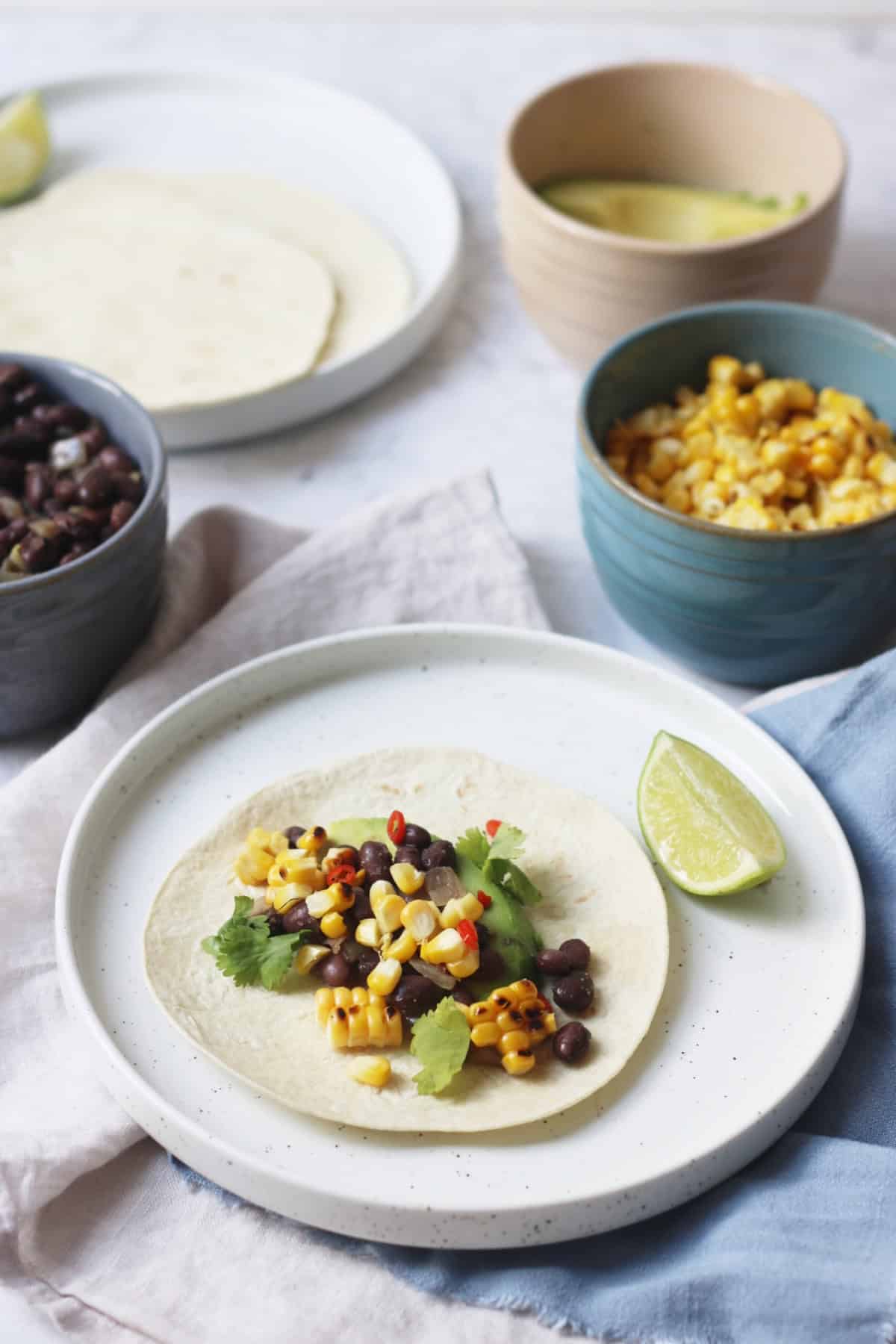 Vegan Corn and Black Bean Tacos served with lime wedges