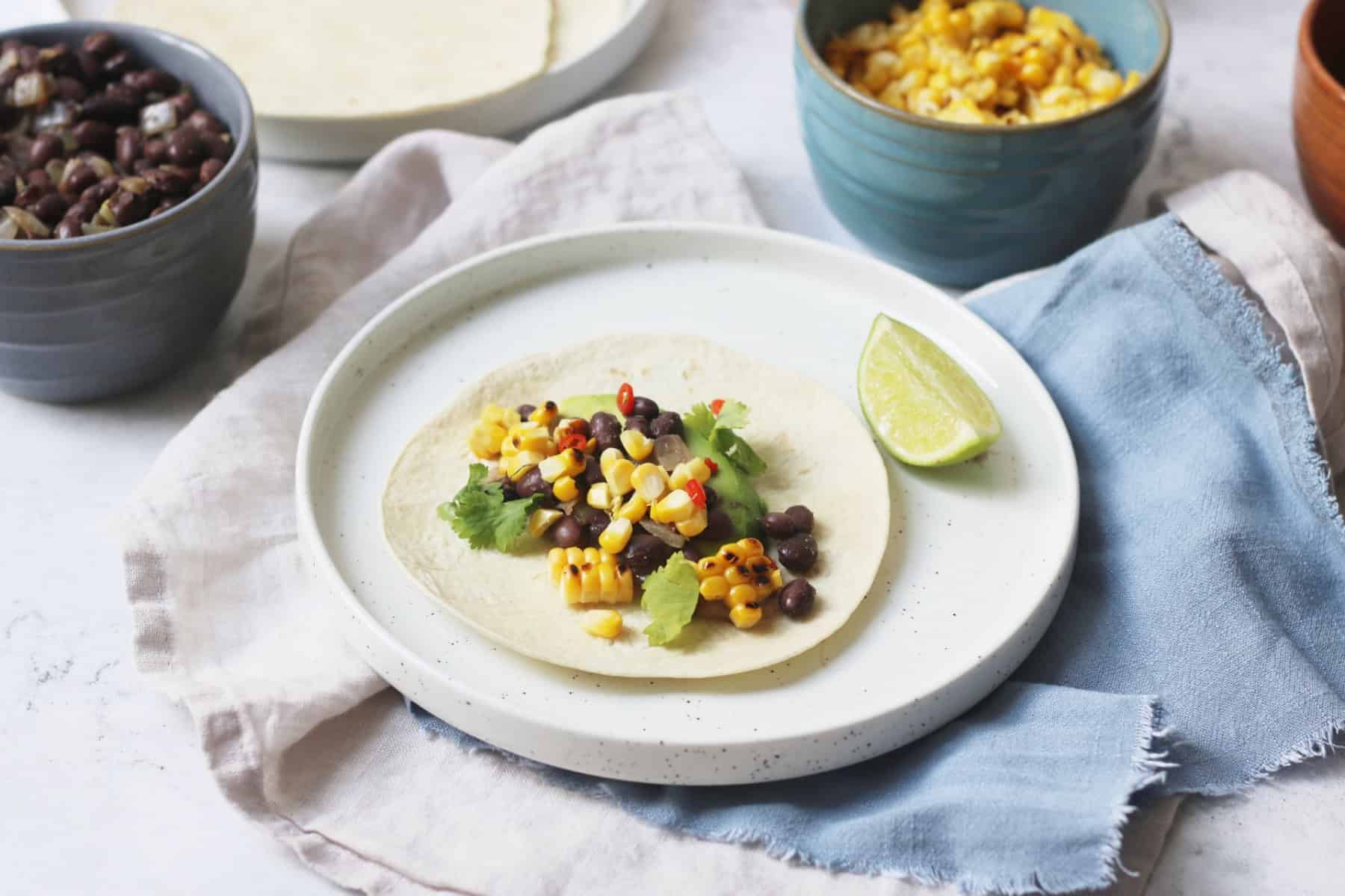 Vegan Corn and Black Bean Tacos served with lime wedges