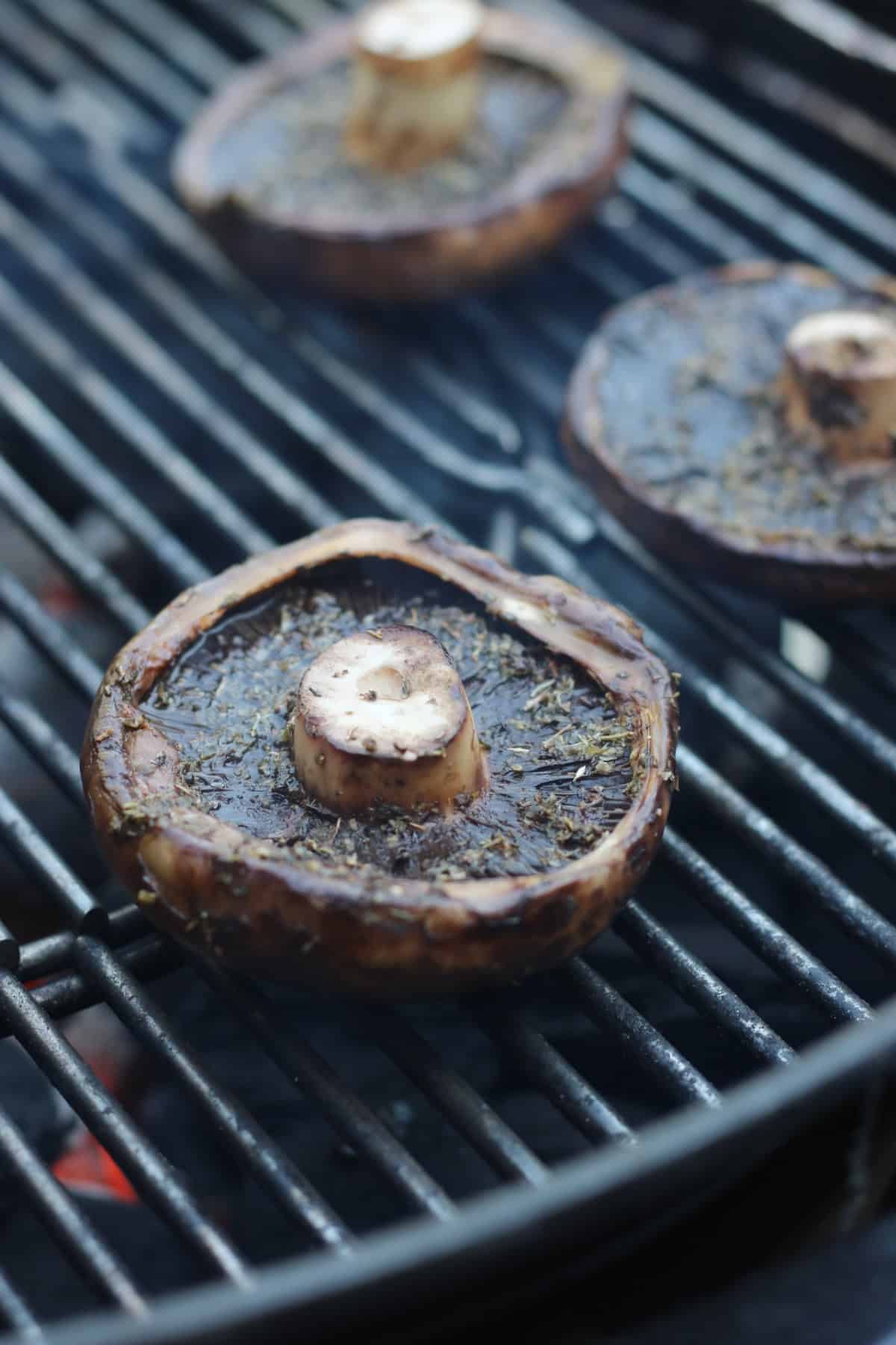 Marinated portobello mushrooms cooking on a BBQ