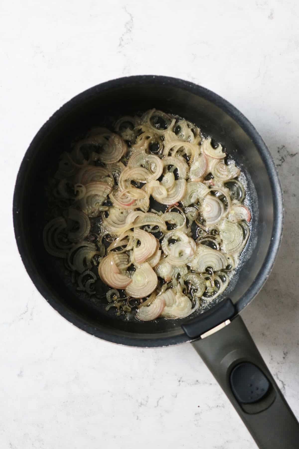 Shallots frying in butter in a saucepan