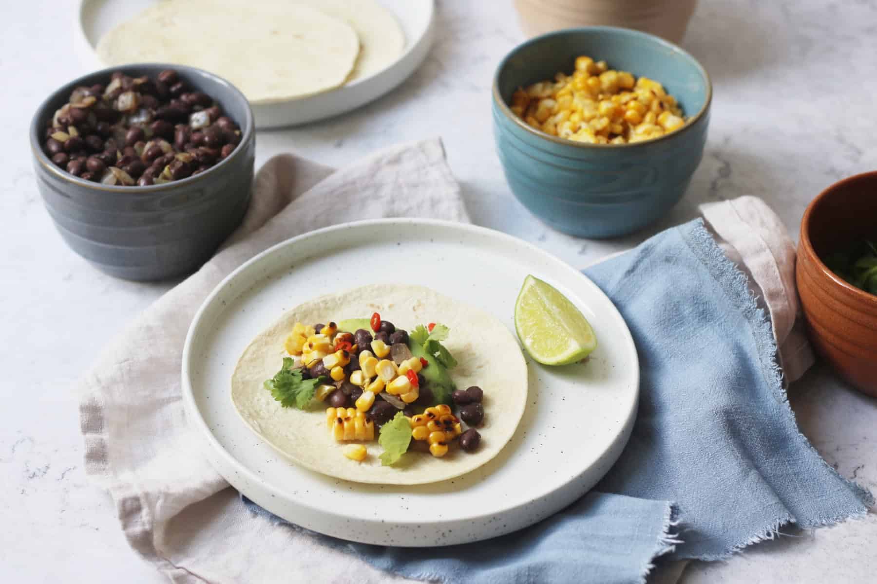 Vegan Corn and Black Bean Tacos served with lime wedges