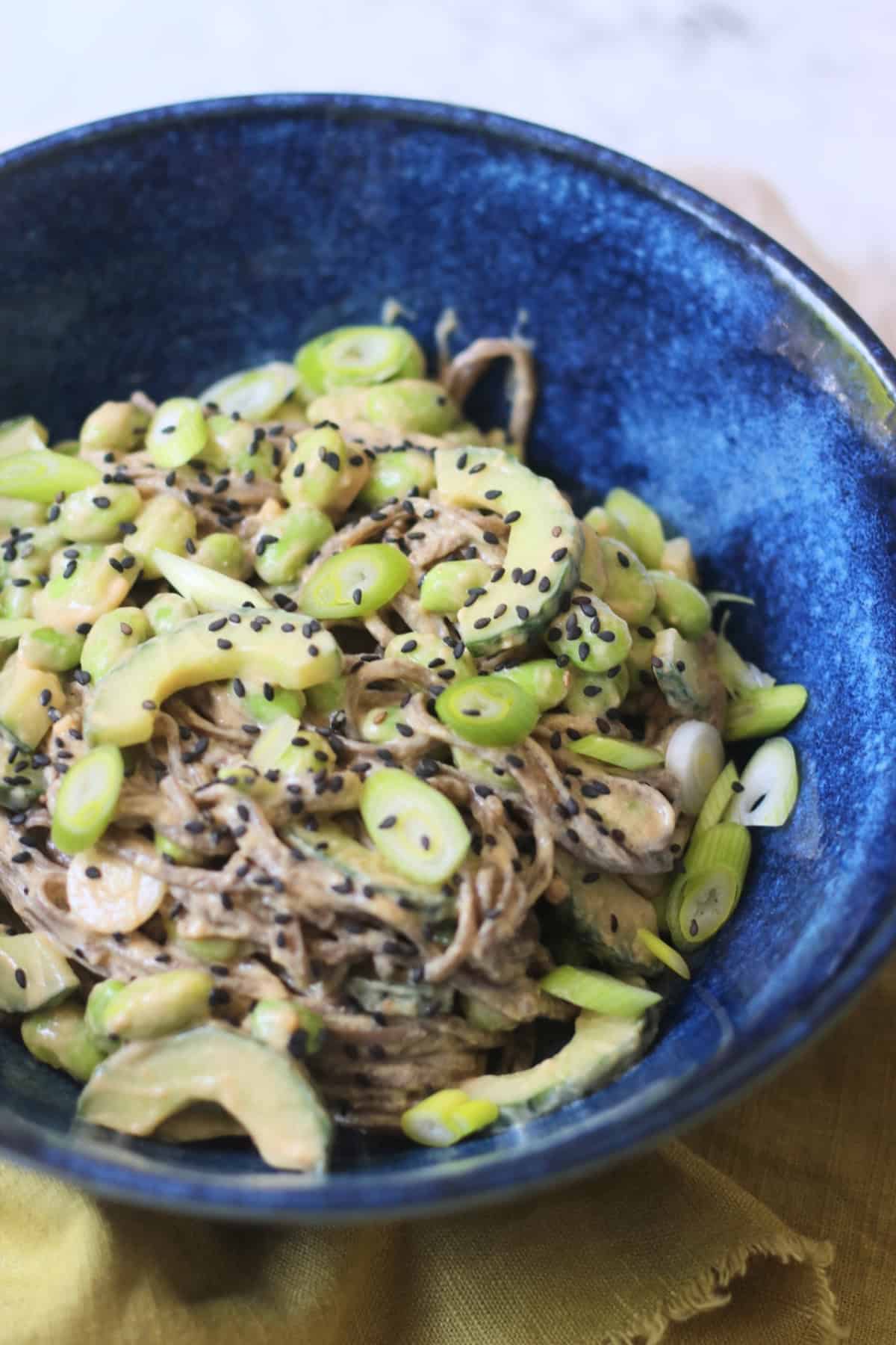 A bowl of Cold Sesame and Peanut Soba Noodles served with a green napkin