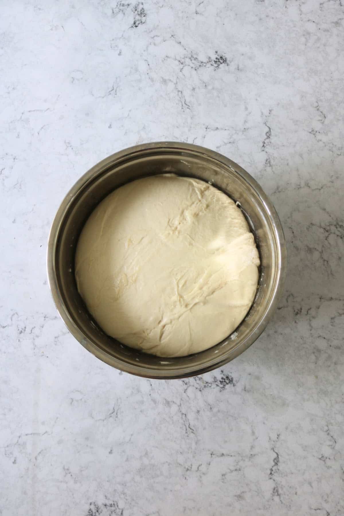 A ball of focaccia dough after its first prove where it has doubled in size