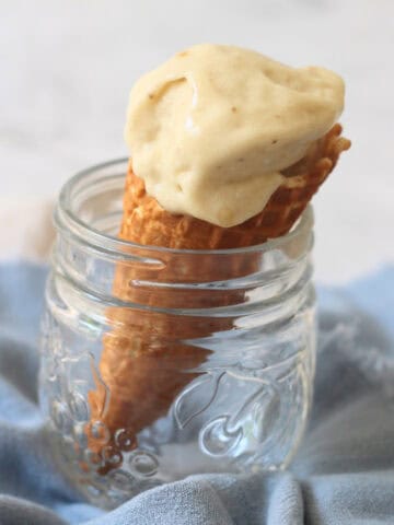 A waffle cone of Vegan Banana and Coconut Ice Cream in a glass jar