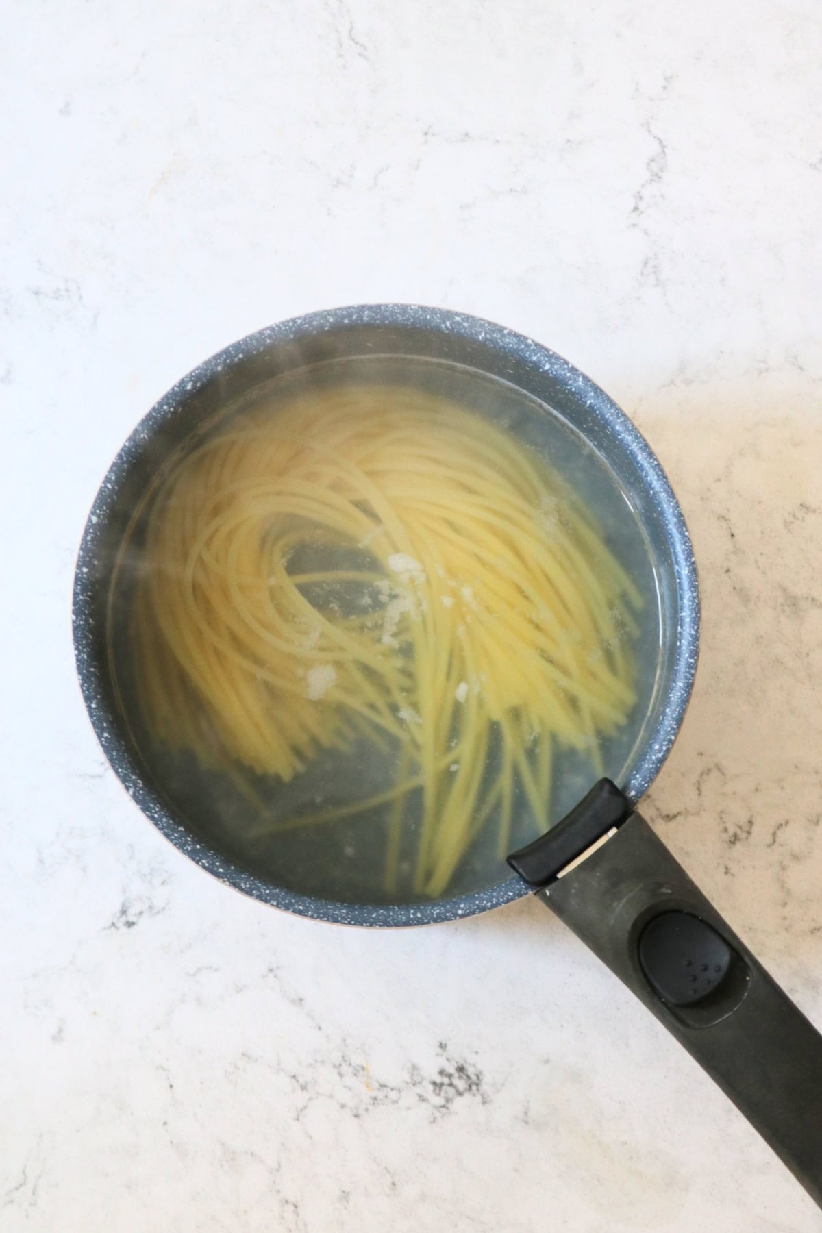 Linguine cooking in a pan of boiling water