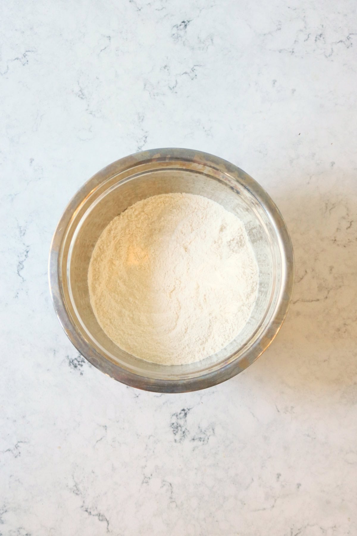 Self raising flour, caster sugar and bicarbonate of soda in a metal mixing bowl