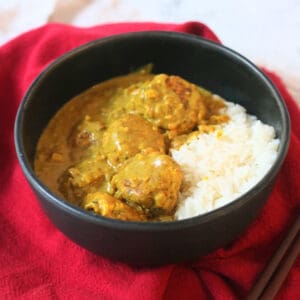 Hong Kong Style Vegan Curry Fish Balls served with white rice in a black bowl with a red napkin