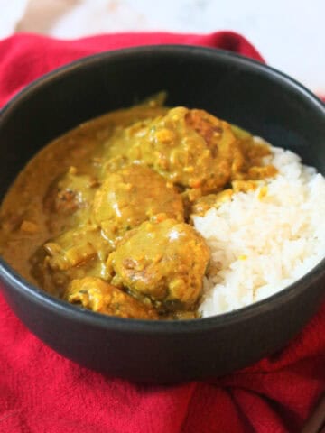 Hong Kong Style Vegan Curry Fish Balls served with white rice in a black bowl with a red napkin