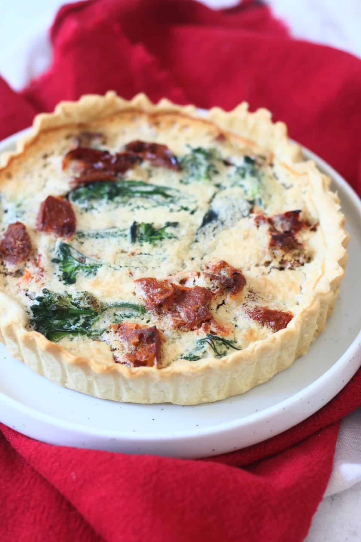 Close up of a whole Vegan Tenderstem Broccoli and Sun-dried Tomato Quiche