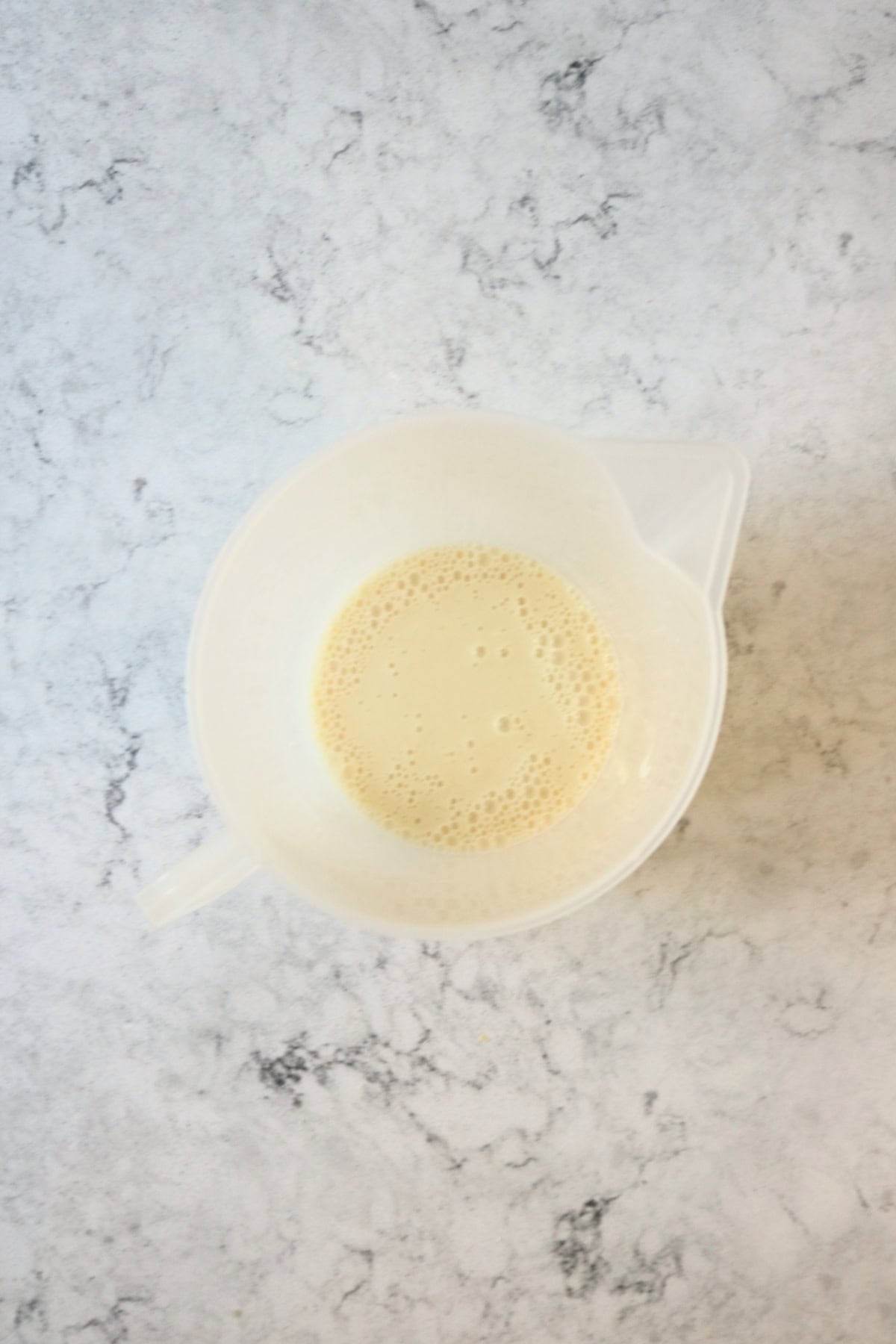 Dairy-free yogurt and plant milk mixed together in a white jug