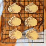 6 Vegan Pumpkin Spice and Pecan Cookies on a wire rack with an orange napkin