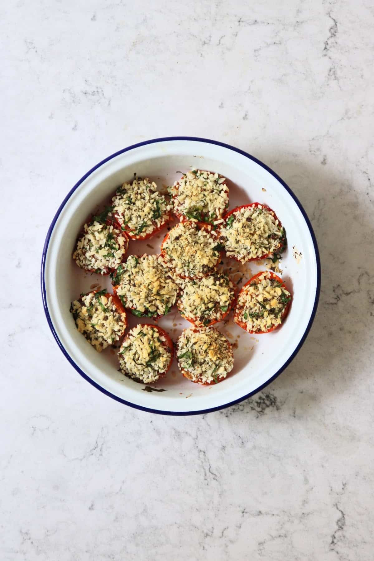 Breadcrumb and herb topped Tomates à la Provençale (Provence Style Tomatoes) in a white and blue enamel dish
