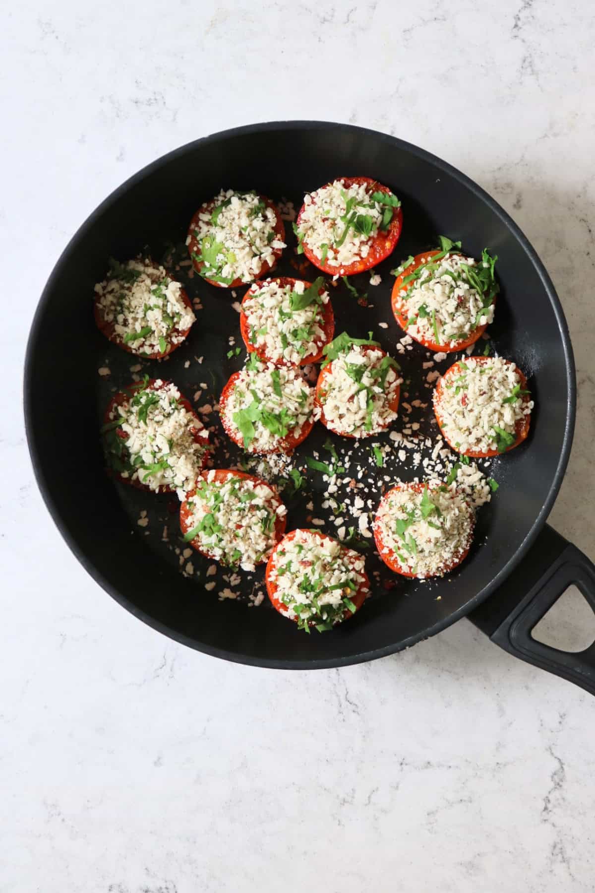 Cooking Tomates à la Provençale (Provence Style Tomatoes) in a large flat-bottomed frying pan
