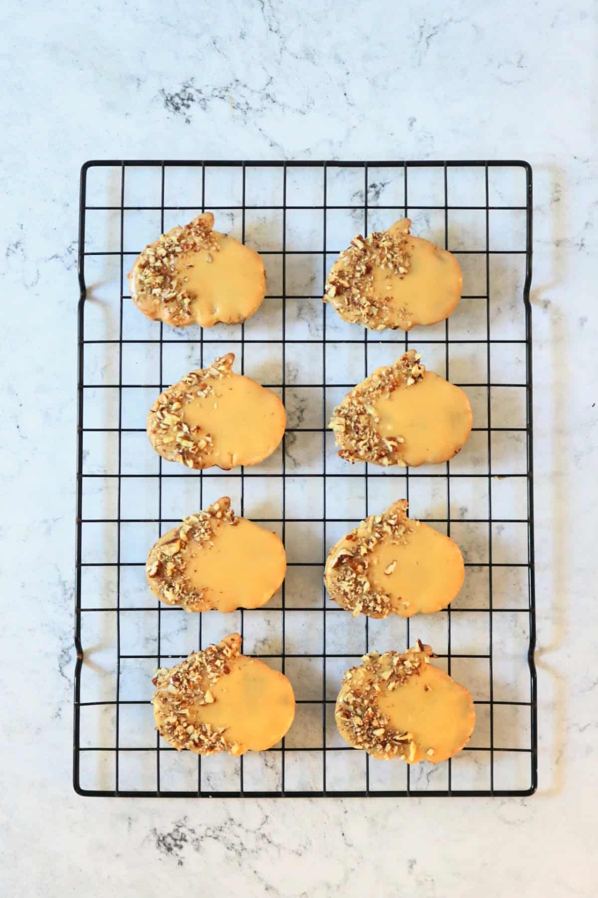 Decorated Vegan Pumpkin Spice and Pecan Cookies on a wire rack